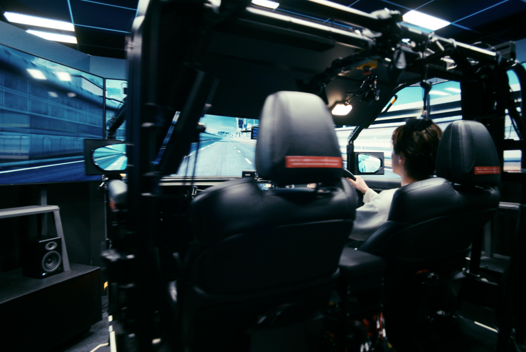 Engineer testing vehicle behavior using driving simulator in controlled environment