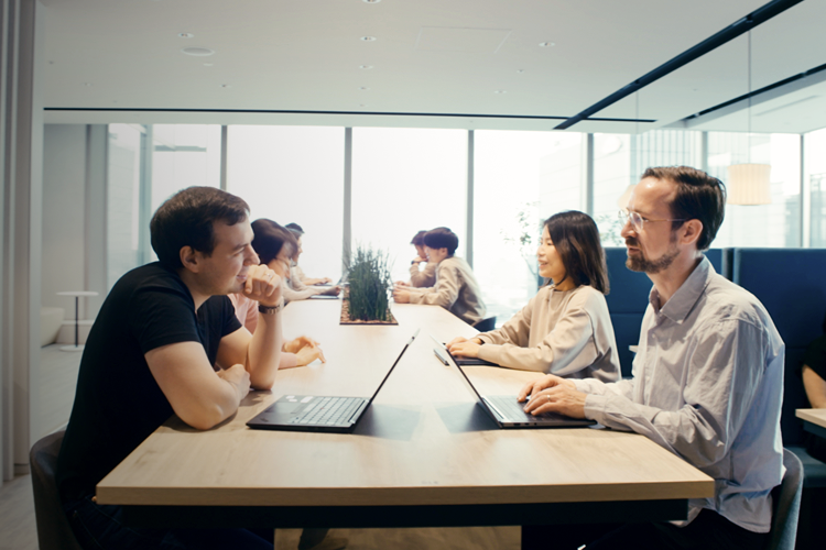Employees collaborating across a table in a modern office environment