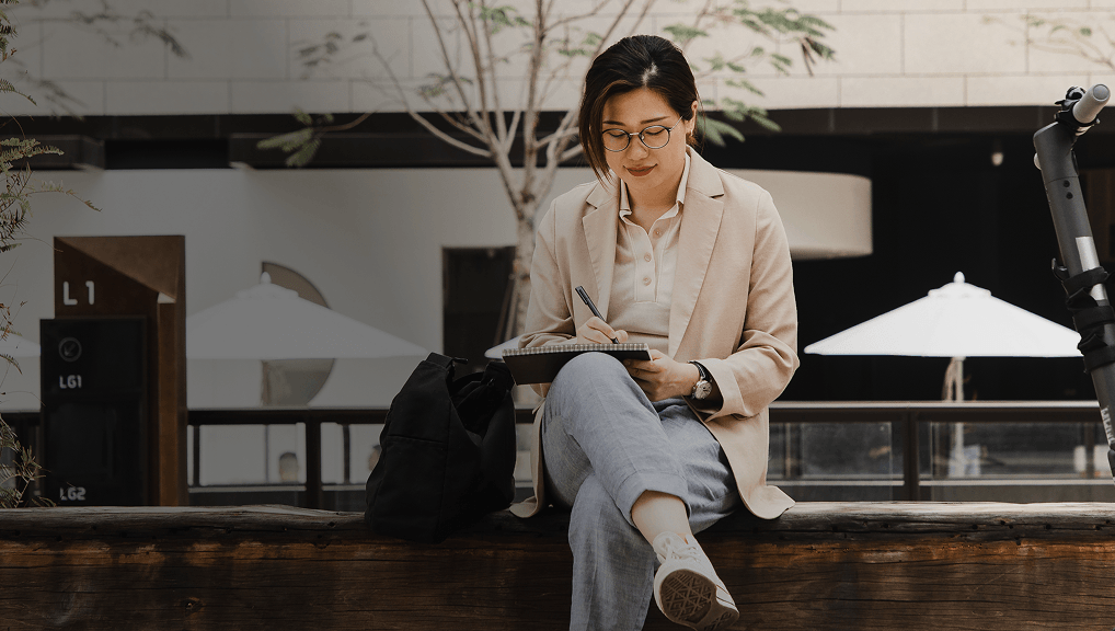 Person sketching on a bench with new mobility solutions in the background